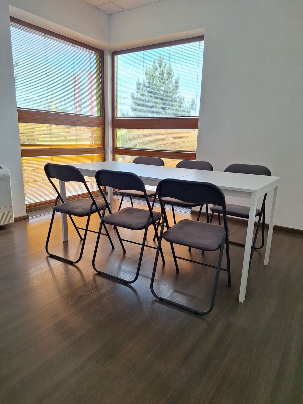 Zasadačka Medium — biely stôl pri rohových oknách